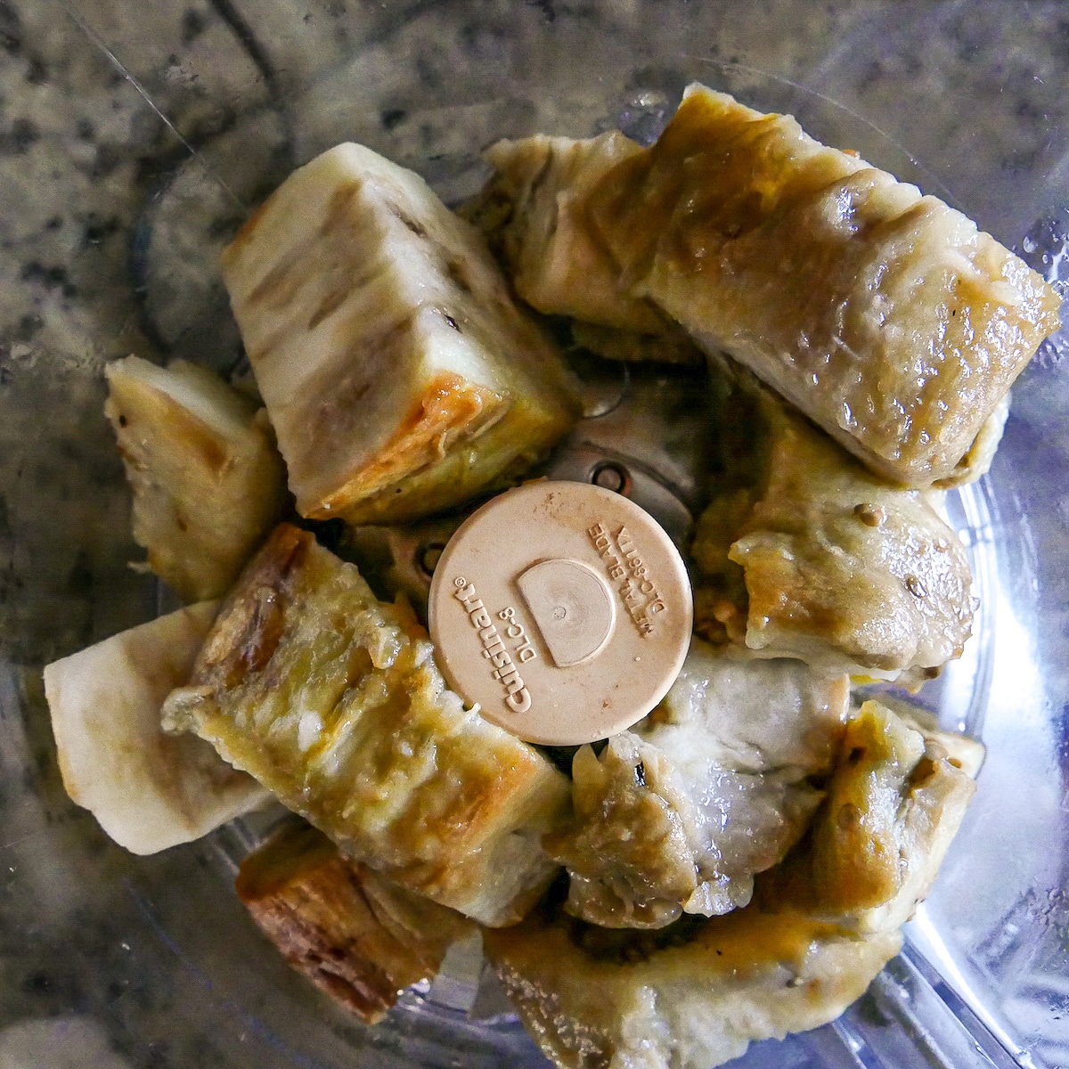 pieces of roasted eggplant in food processor.