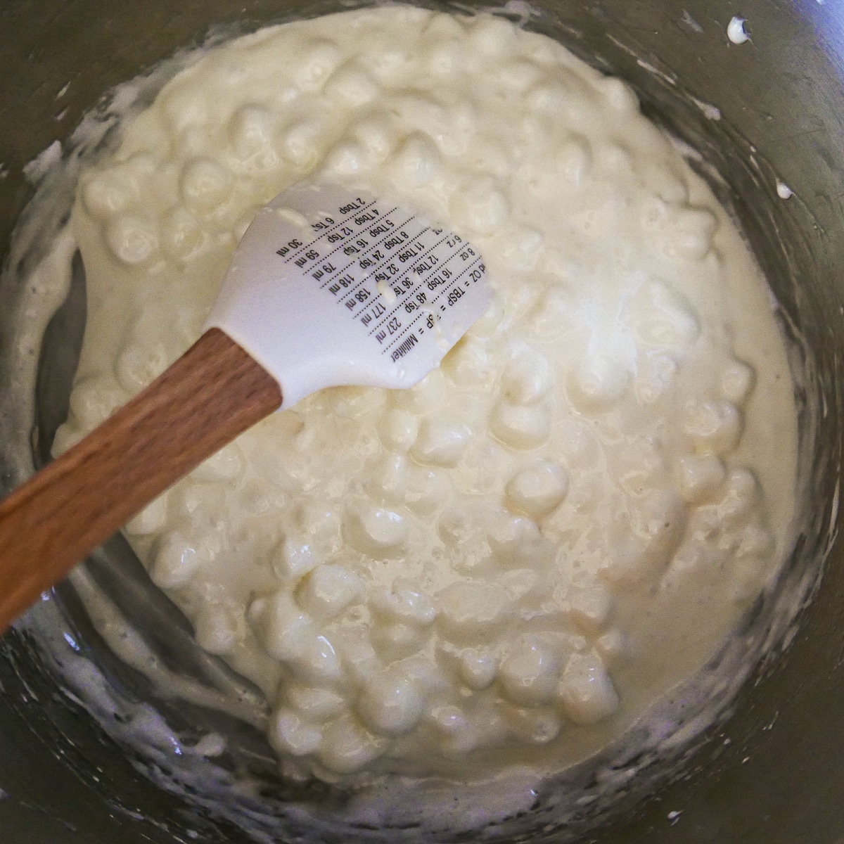 marshmallows being stirred into melted butter.