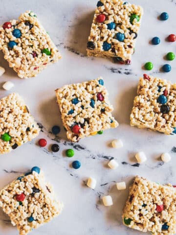 Rice krispie treats with m&m's arranged on a table.