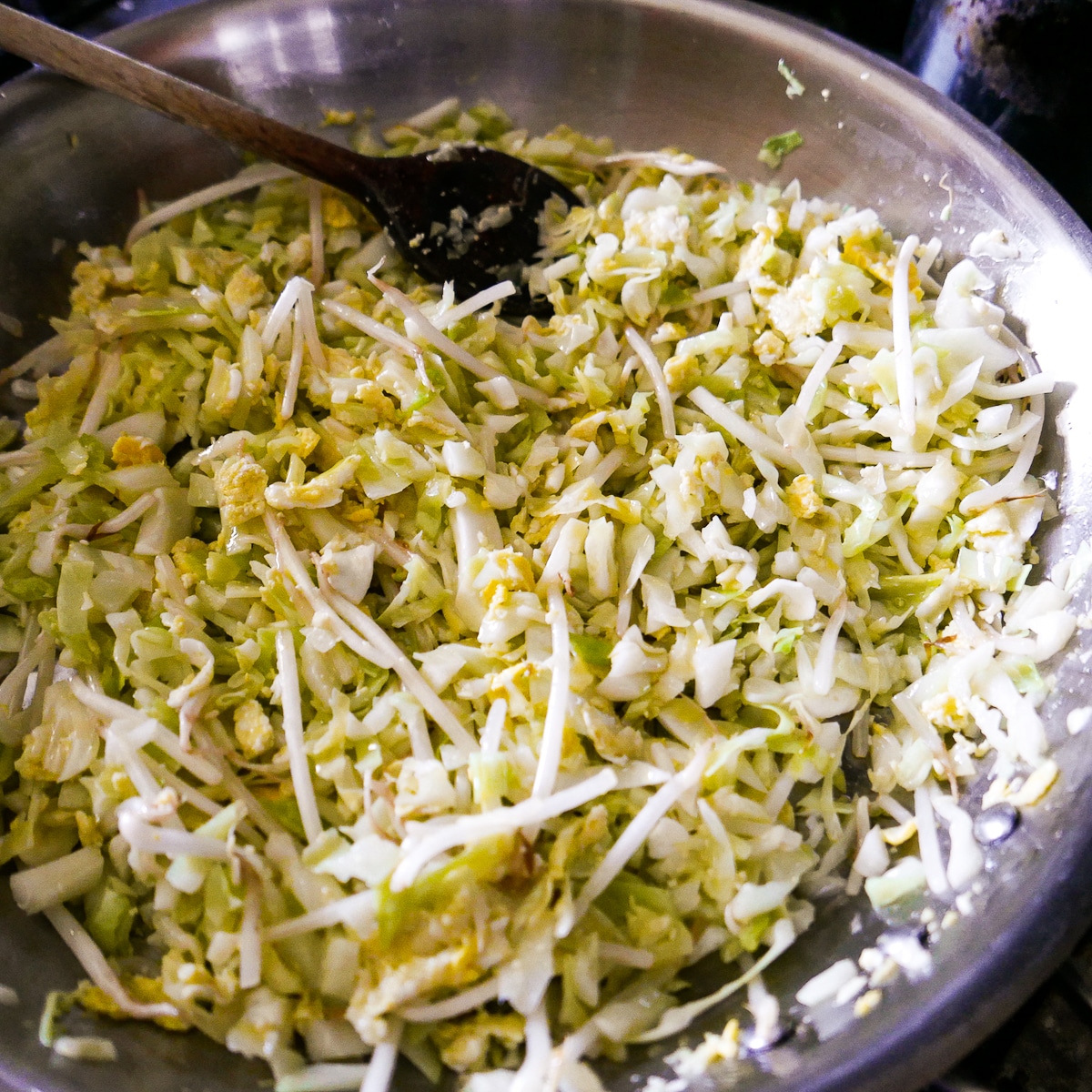 ingredients-in-skillet.jpg Cabbage and bean sprouts being cooked with eggs in a skillet.
