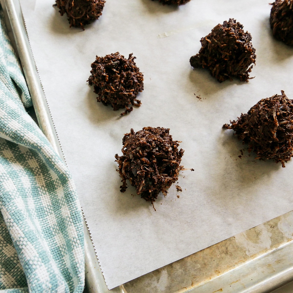 Macaroons scooped onto a parchment paper-lined baking sheet.