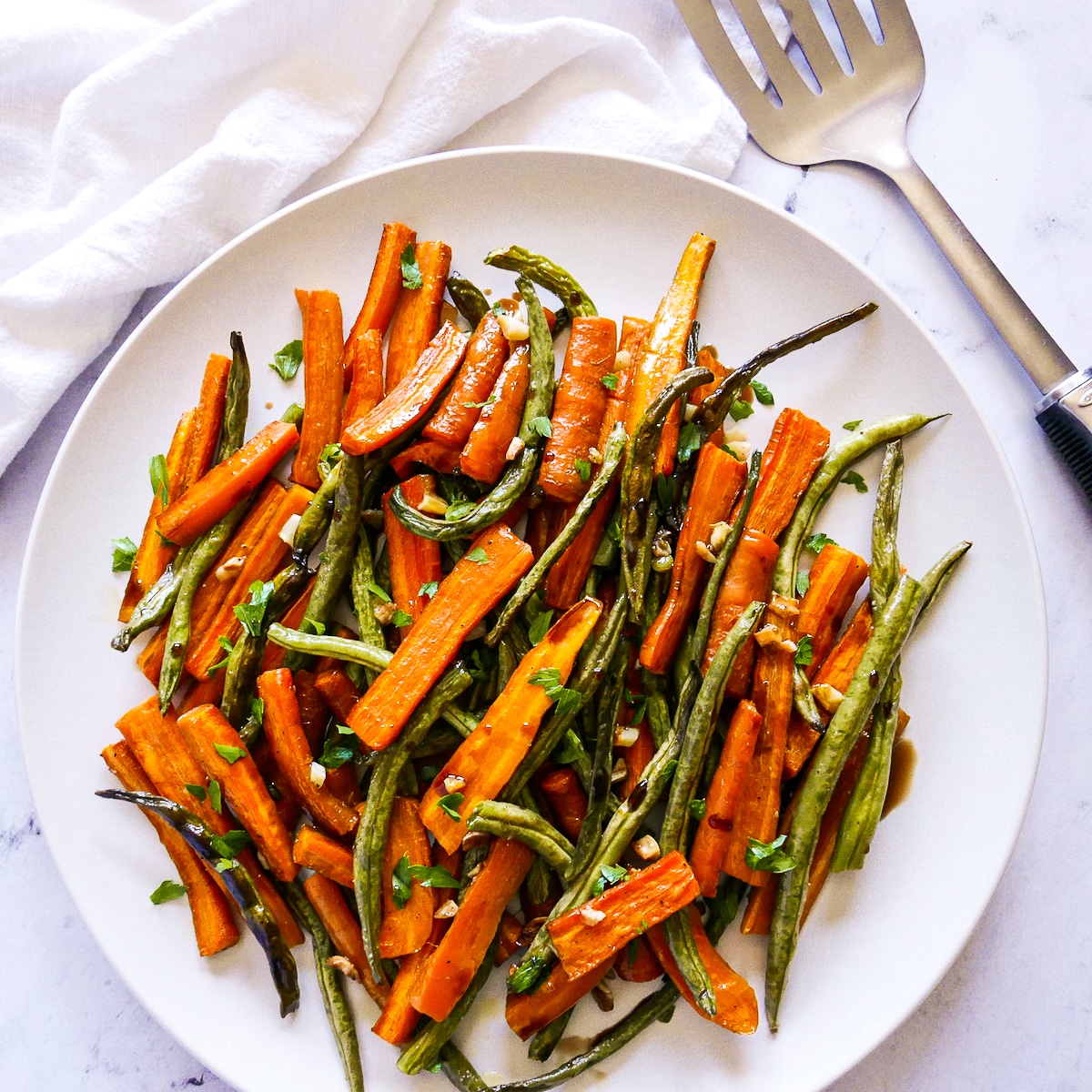 platter of roasted vegetables with a spatula on the side.