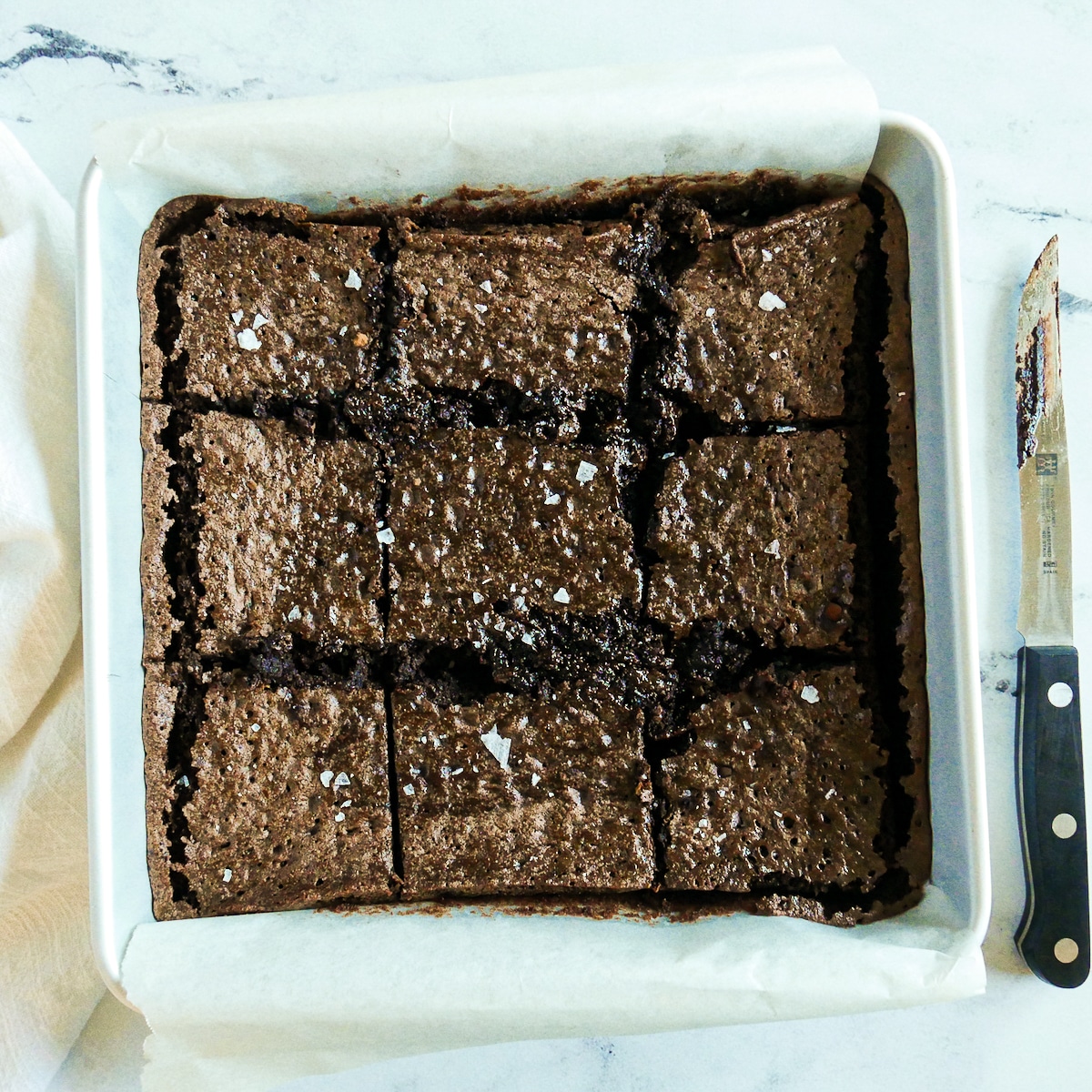 Square pan of brownies cut into nine pieces.