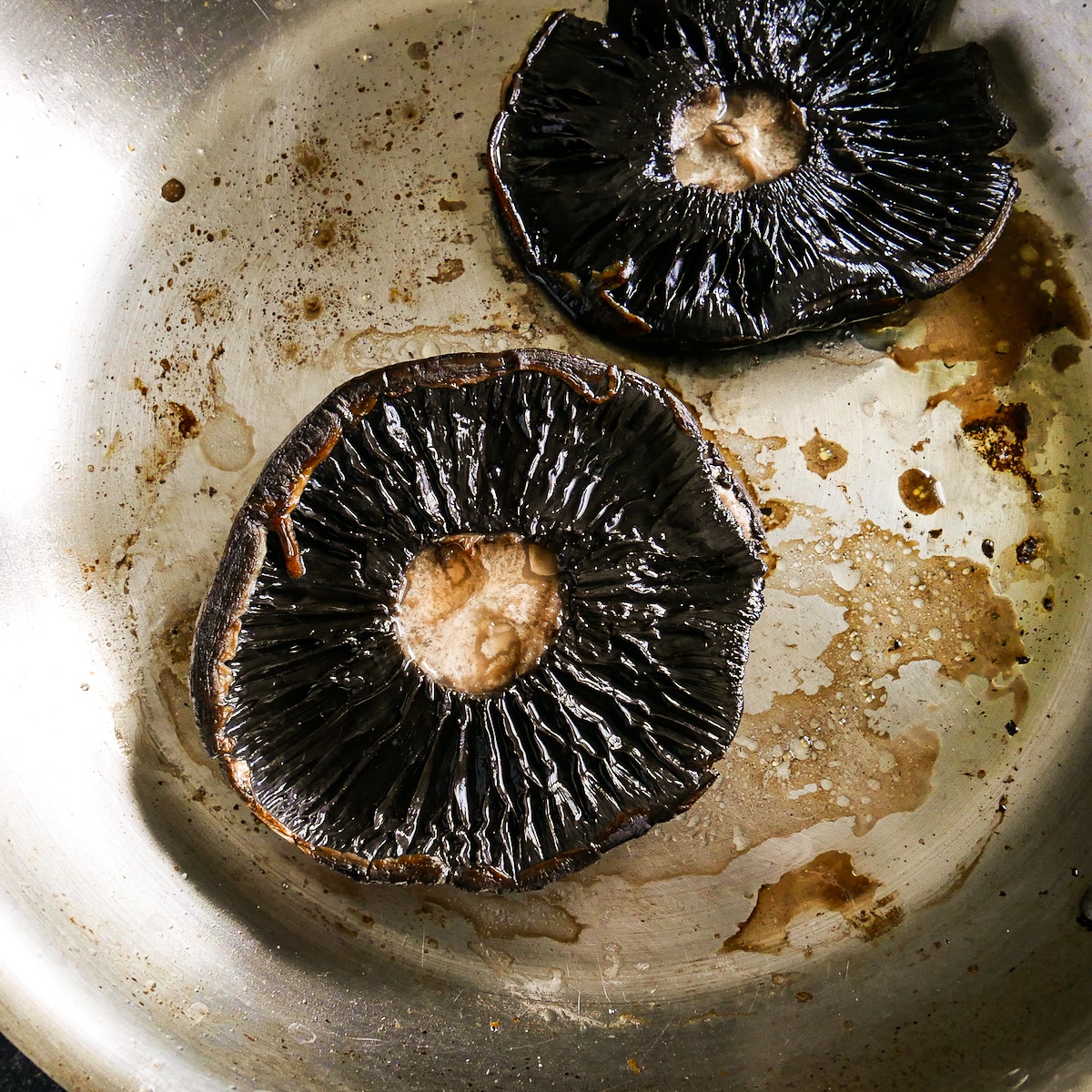 Mushrooms placed in skillet gill side up.