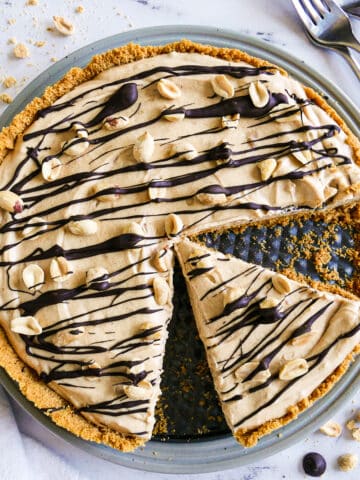 peanut butter pie with one slice cut and garnished with peanuts.