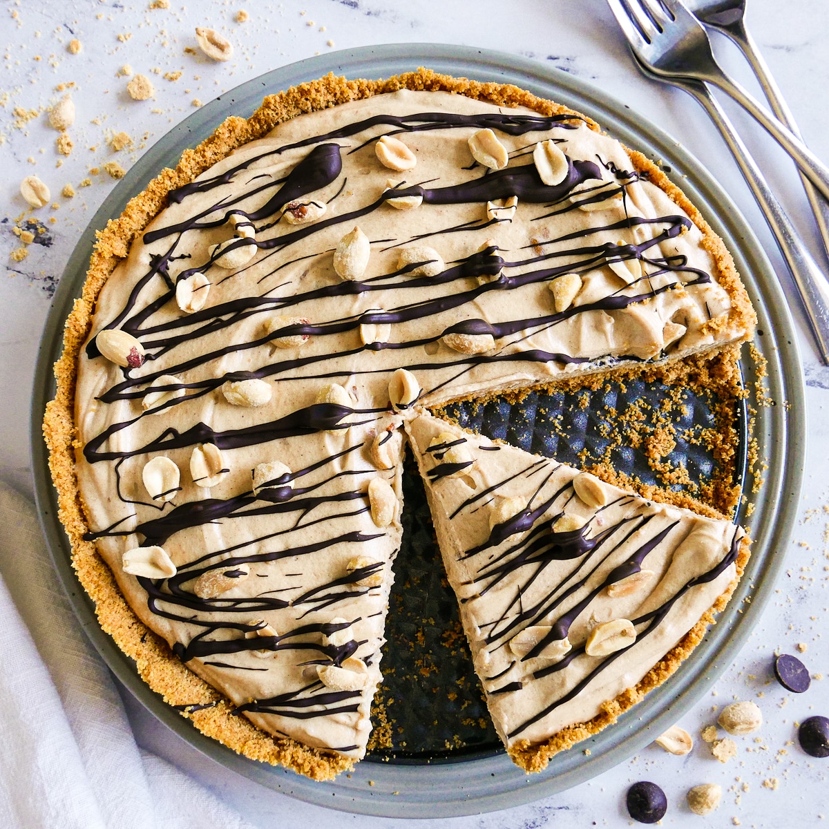 peanut butter pie with one slice cut and garnished with peanuts.