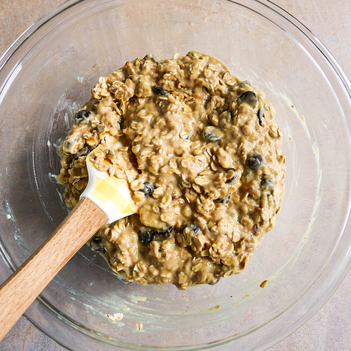 Cookie mixture in a mixing bowl with a rubber spatula.