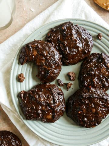 4 ingredient cookies arranged on a blue plate with crumbs.