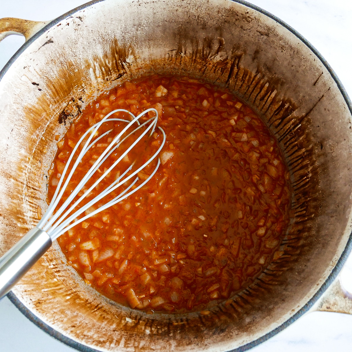 Seasoning added to onion mixture cooking on stove.