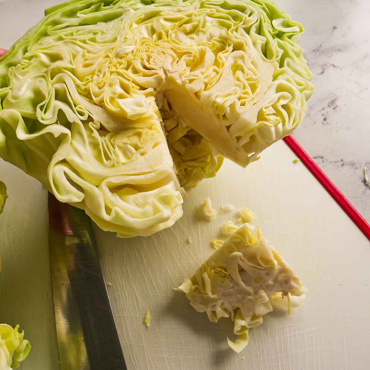 Half of cabbage with core cut out of it.