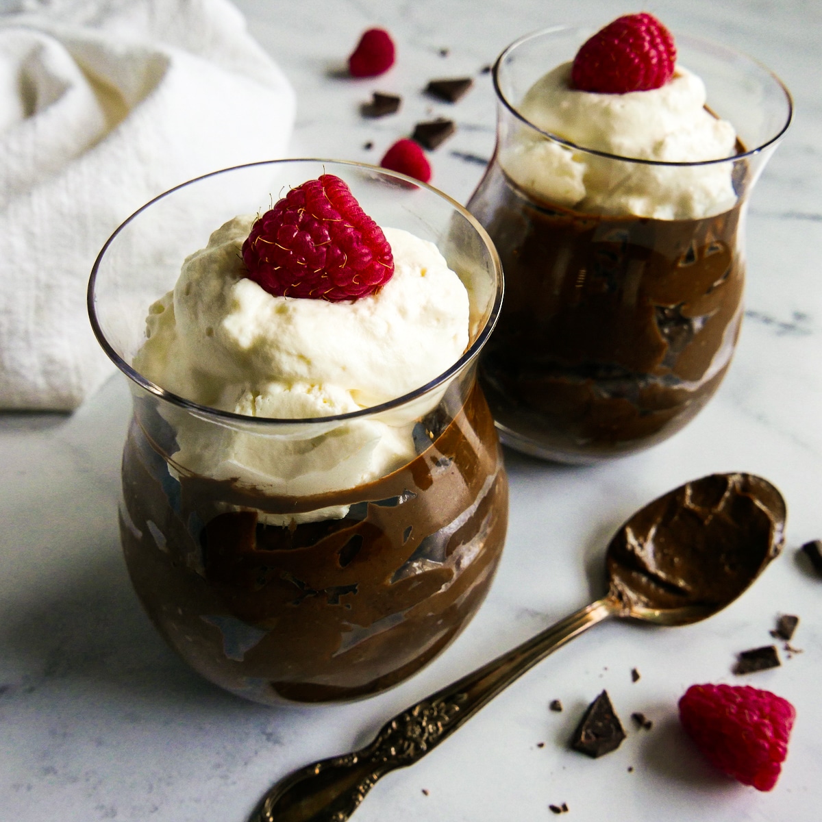 cups-of-mousse.jpg Two glass cups with avocado chocolate mousse and topped with whipped cream.