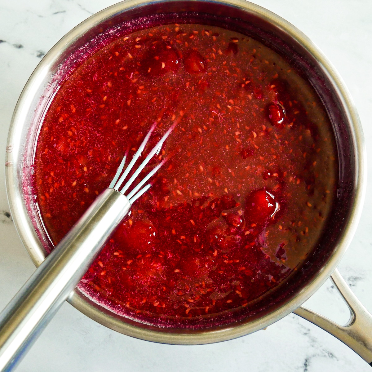 Raspberry mixture added to pectin mixture in saucepan.