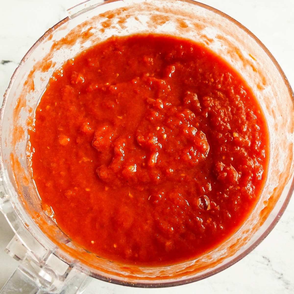 Chopped tomatoes in a food processor.