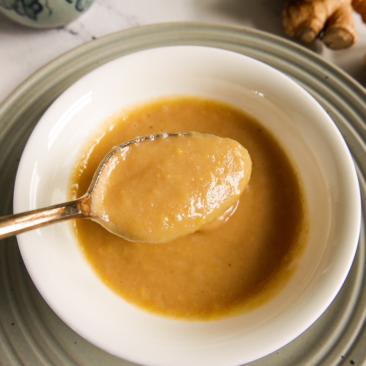 Spooning up miso dipping sauce from a cup.