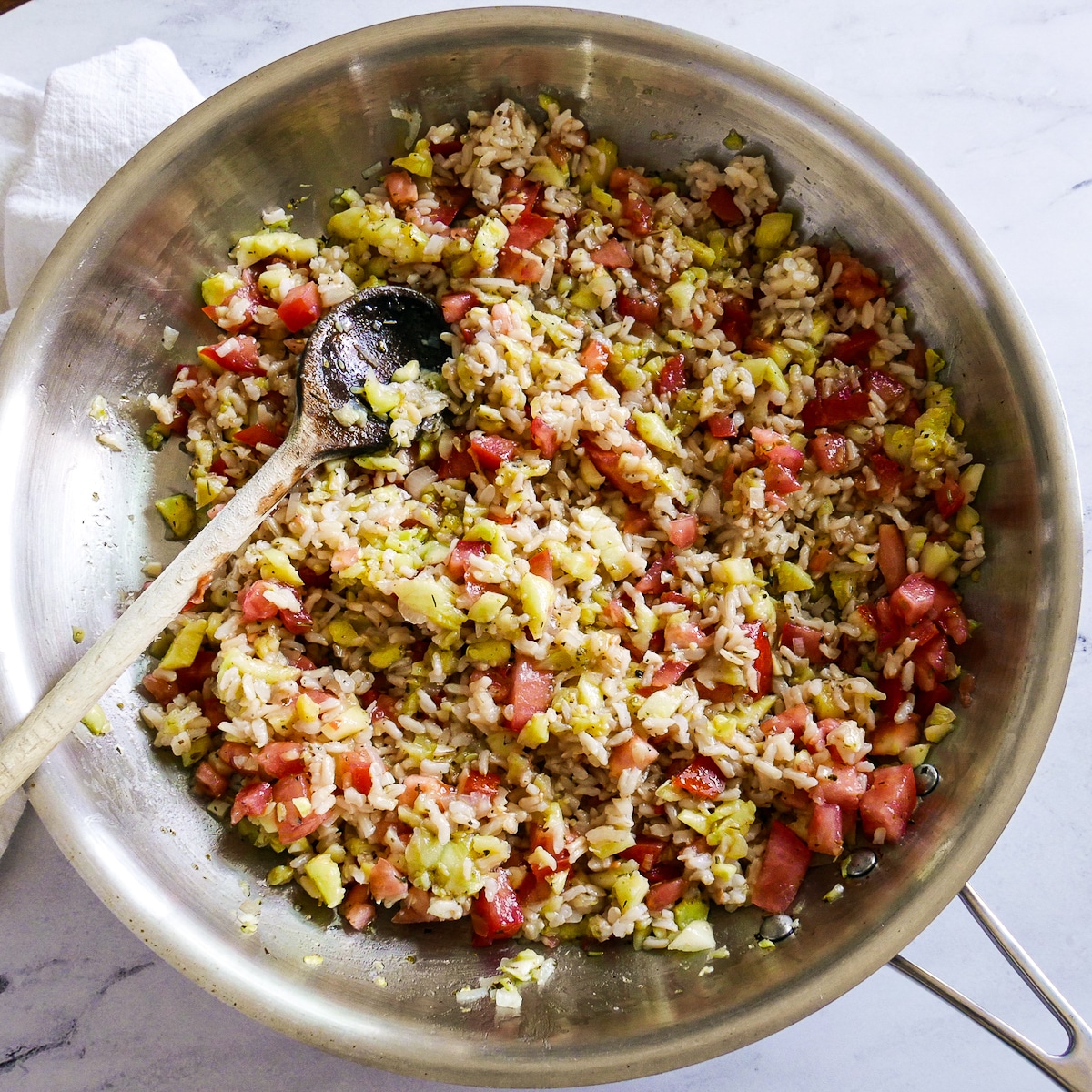 rice-tomato-and-zucchini.jpg Cooked rice and diced tomato added to seasoned zucchini mixture in a skillet.