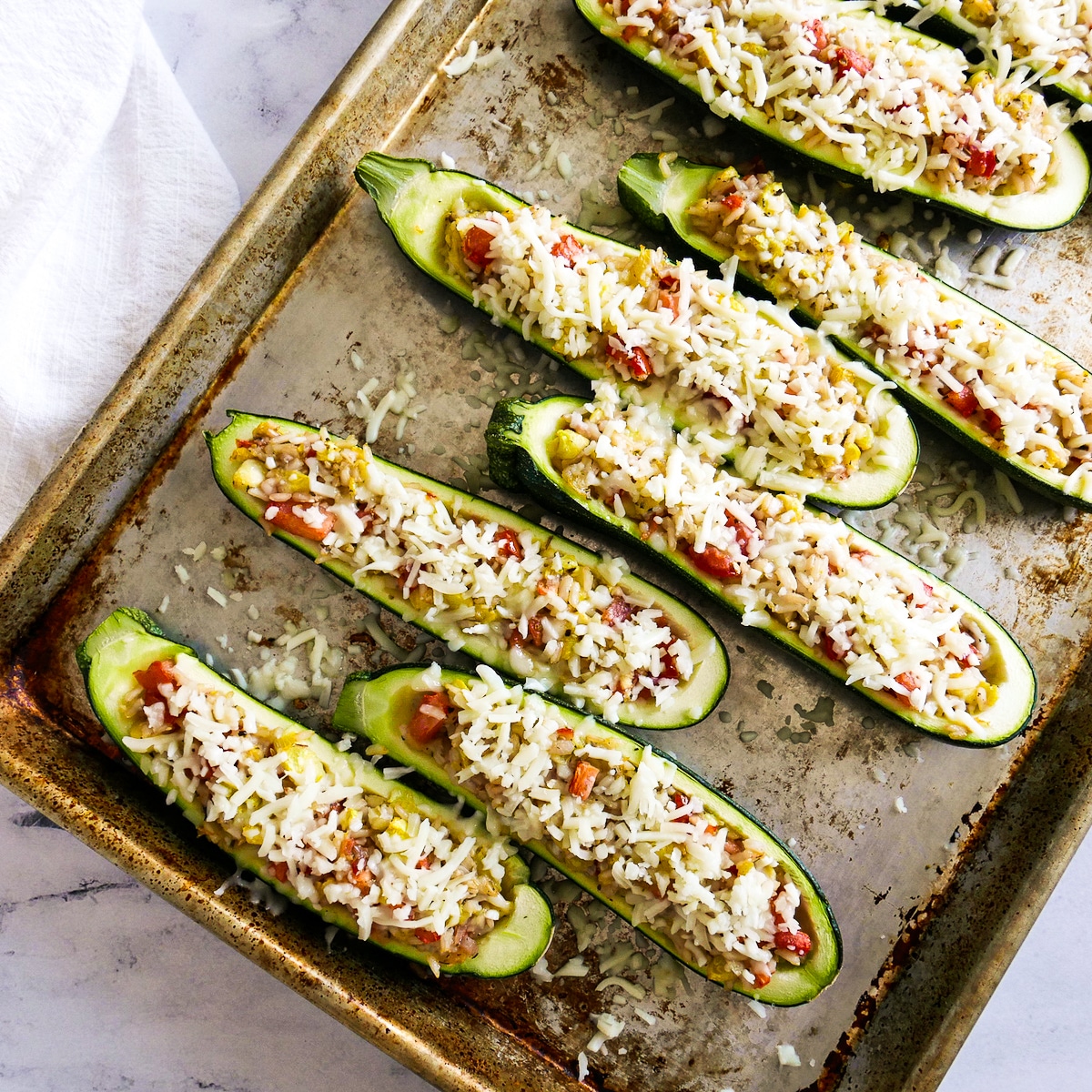 mozzarella-on-zucchini.jpg Shredded mozzarella sprinkled on top of assembled zucchini boats.
