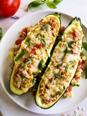 Two pieces of stuffed zucchini arranged on a white plate.