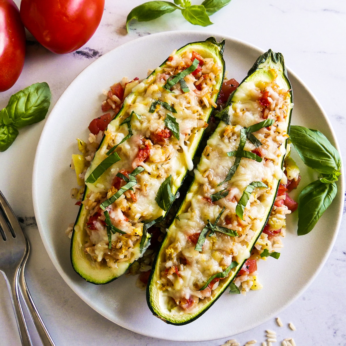 Two pieces of stuffed zucchini arranged on a white plate.