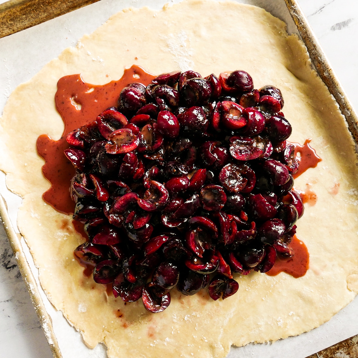 cherry-filling-on-dough.jpg Cherry filling placed on top of rolled out dough.