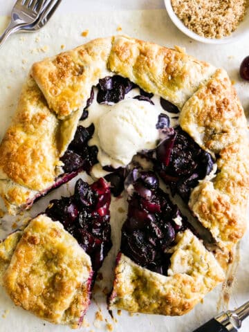 Rustic cherry galette topped with vanilla ice cream.