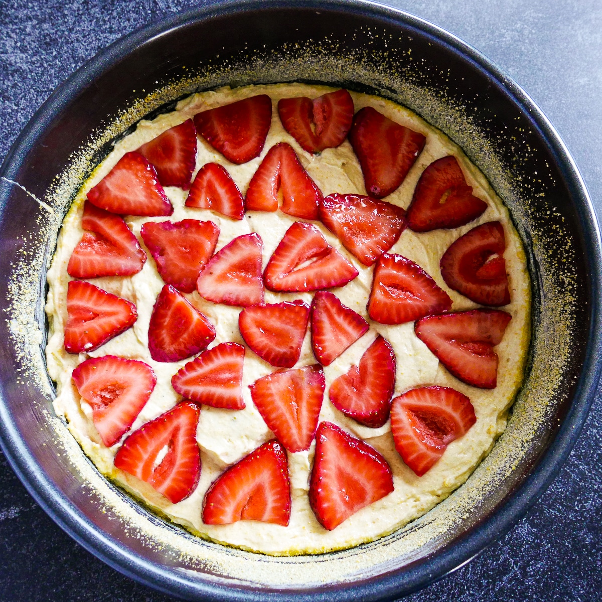 strawberries-on-cake-batter.jpg Sliced strawberries arranged on top of cake batter.