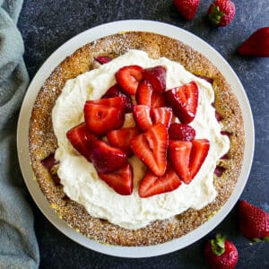Strawberry buttermilk cake topped with whipped cream and strawberries.