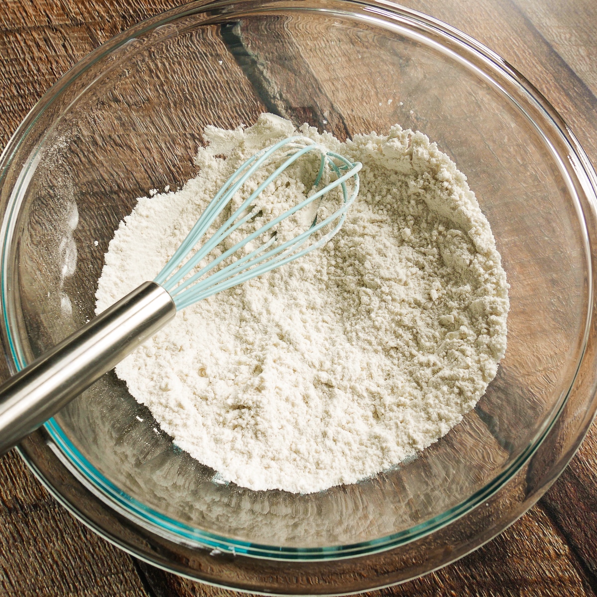 Dry ingredients whisked together in a glass bowl.