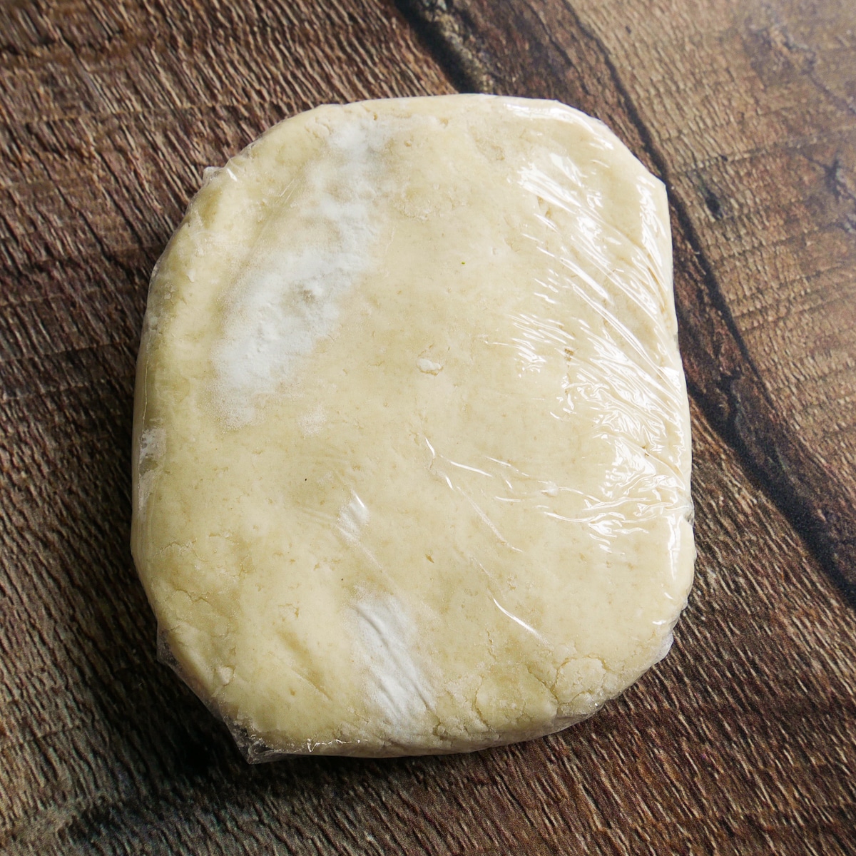 Gluten free galette dough wrapped in plastic wrap.