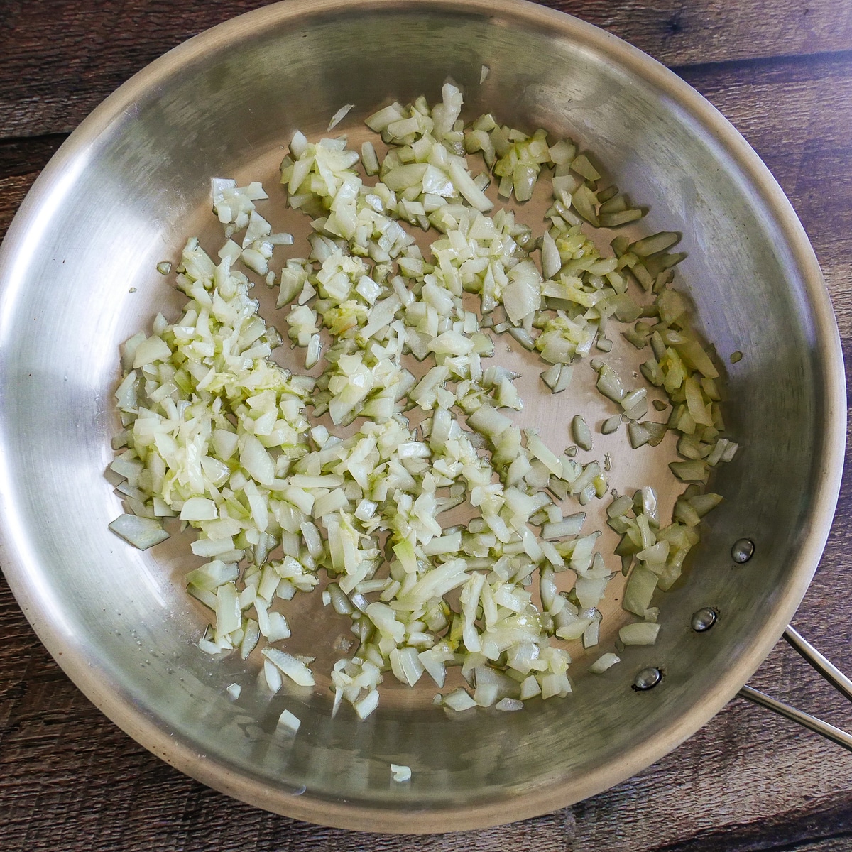 Onion and garlic cooking in a large saute pan.