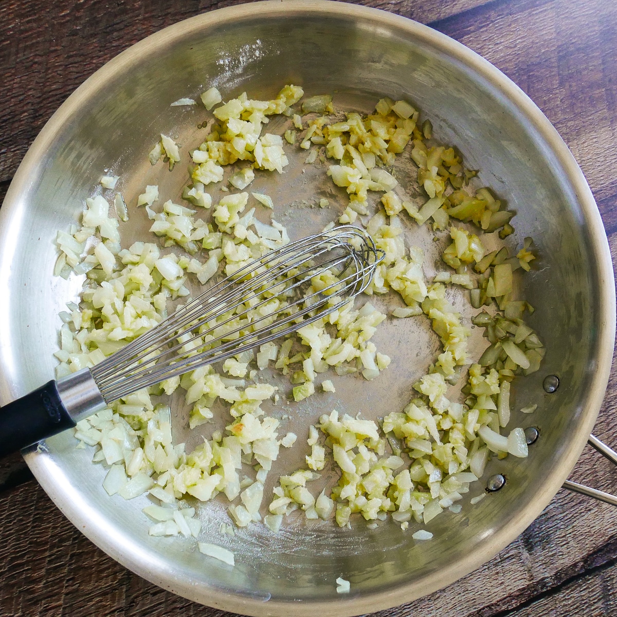 Flour whisked into onion mixture in a saute pan.