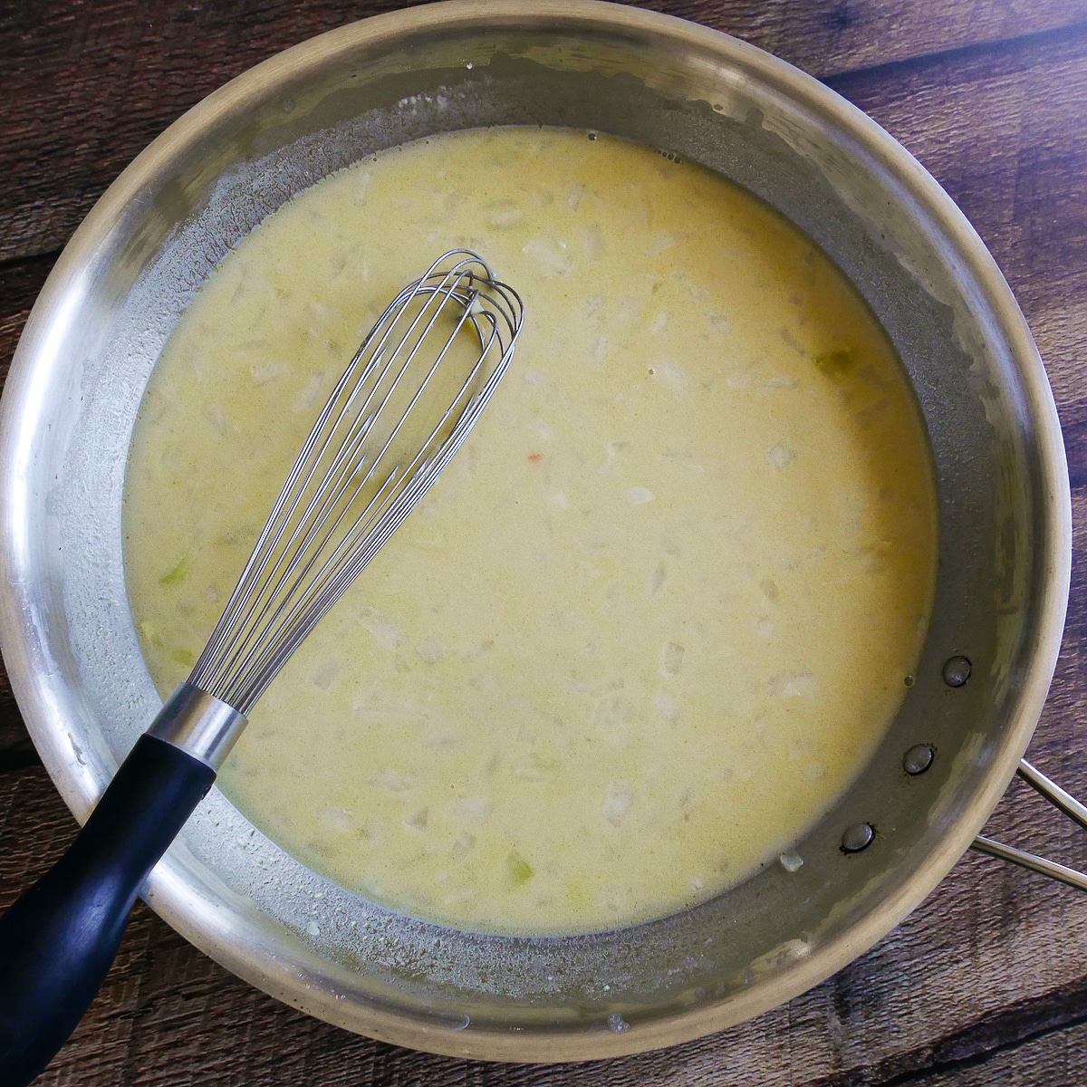 Milk and vegetable broth whisked into onion mixture.