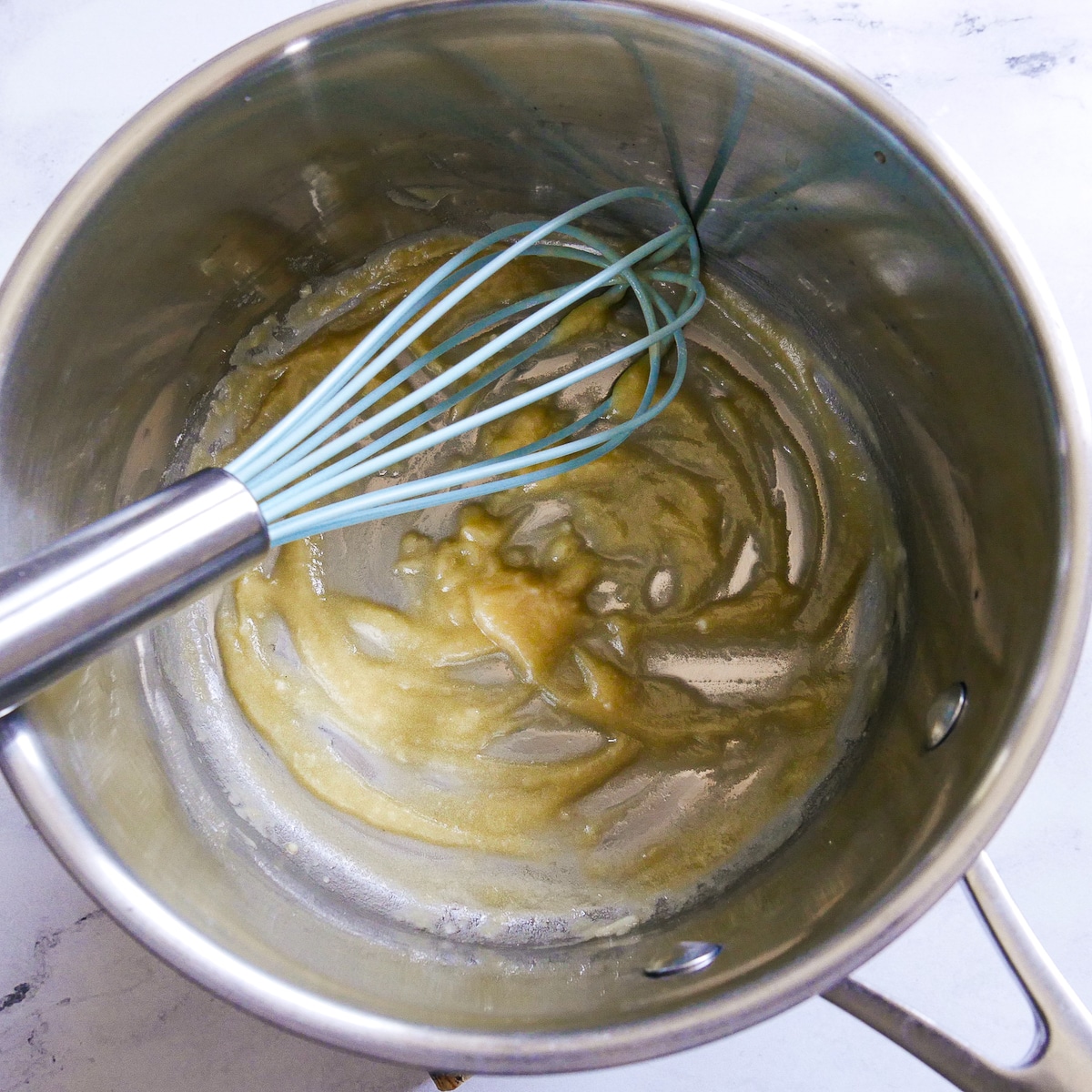 Roux in a saucepan with a whisk.