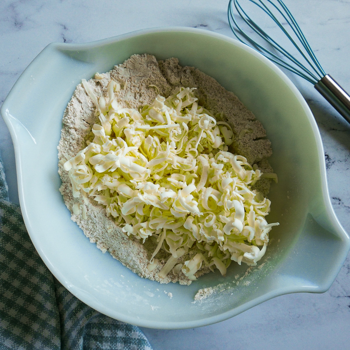 grated-butter.jpg grated butter on top of dry ingredients in a medium bowl.