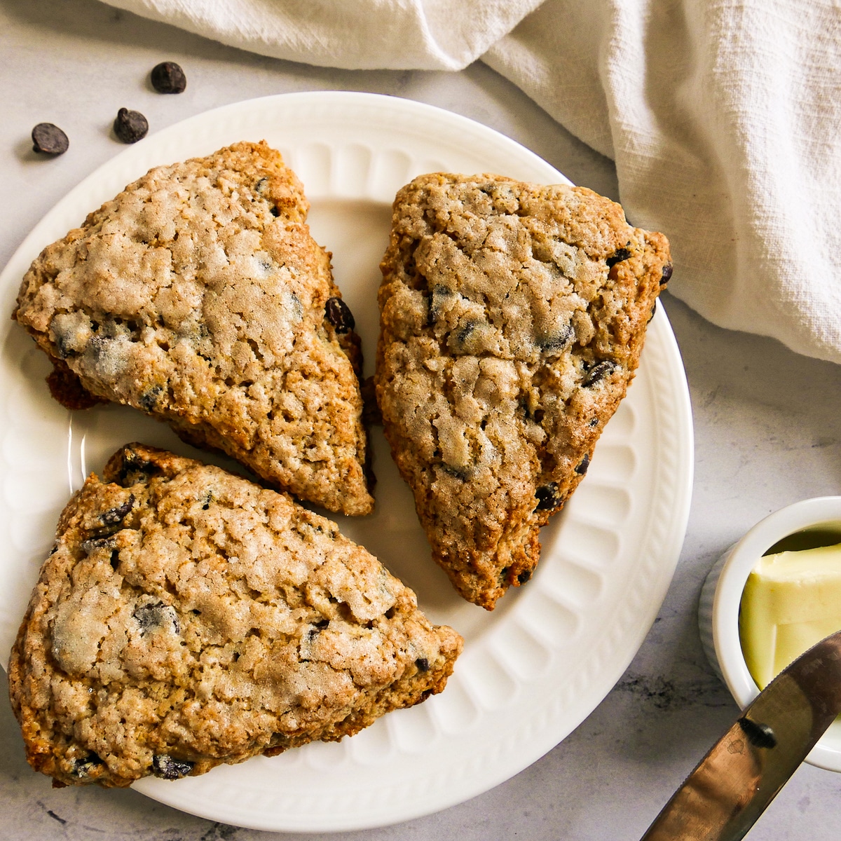 three sourdough scones arranged on a white plate with white napkin.