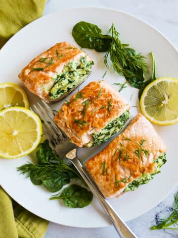 plate of stuffed salmon with spinach and cream cheese on a platter.