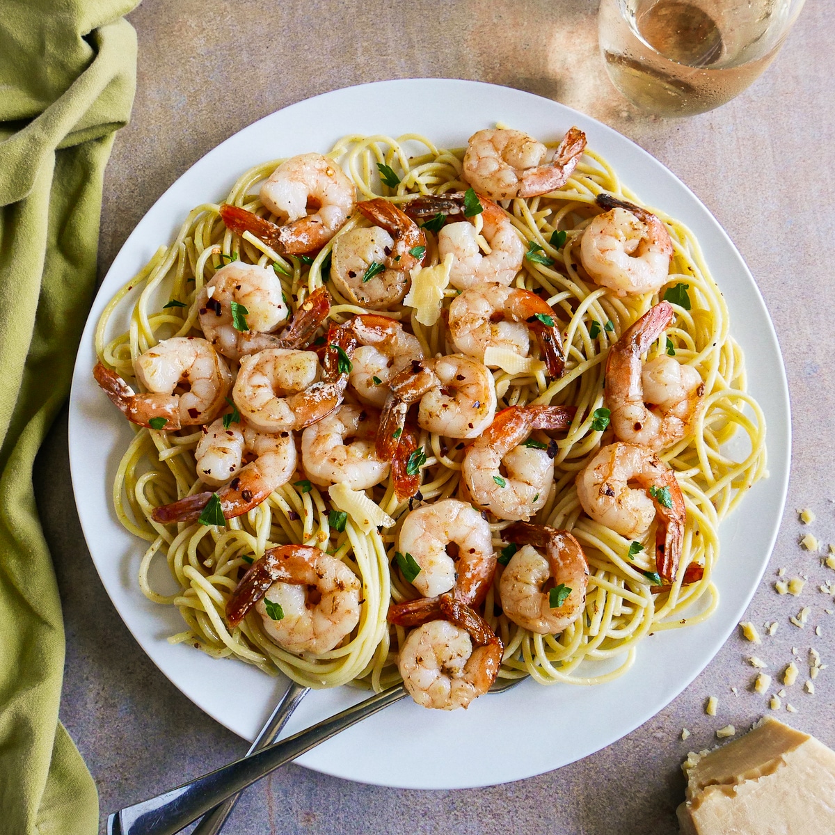 Large plate of garlic shrimp spaghetti with two forks. 