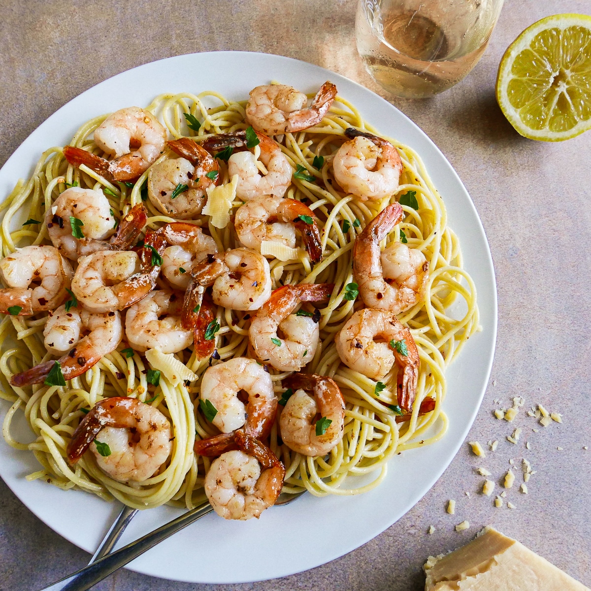 Spaghetti with shrimp on a plate with fresh parsley.