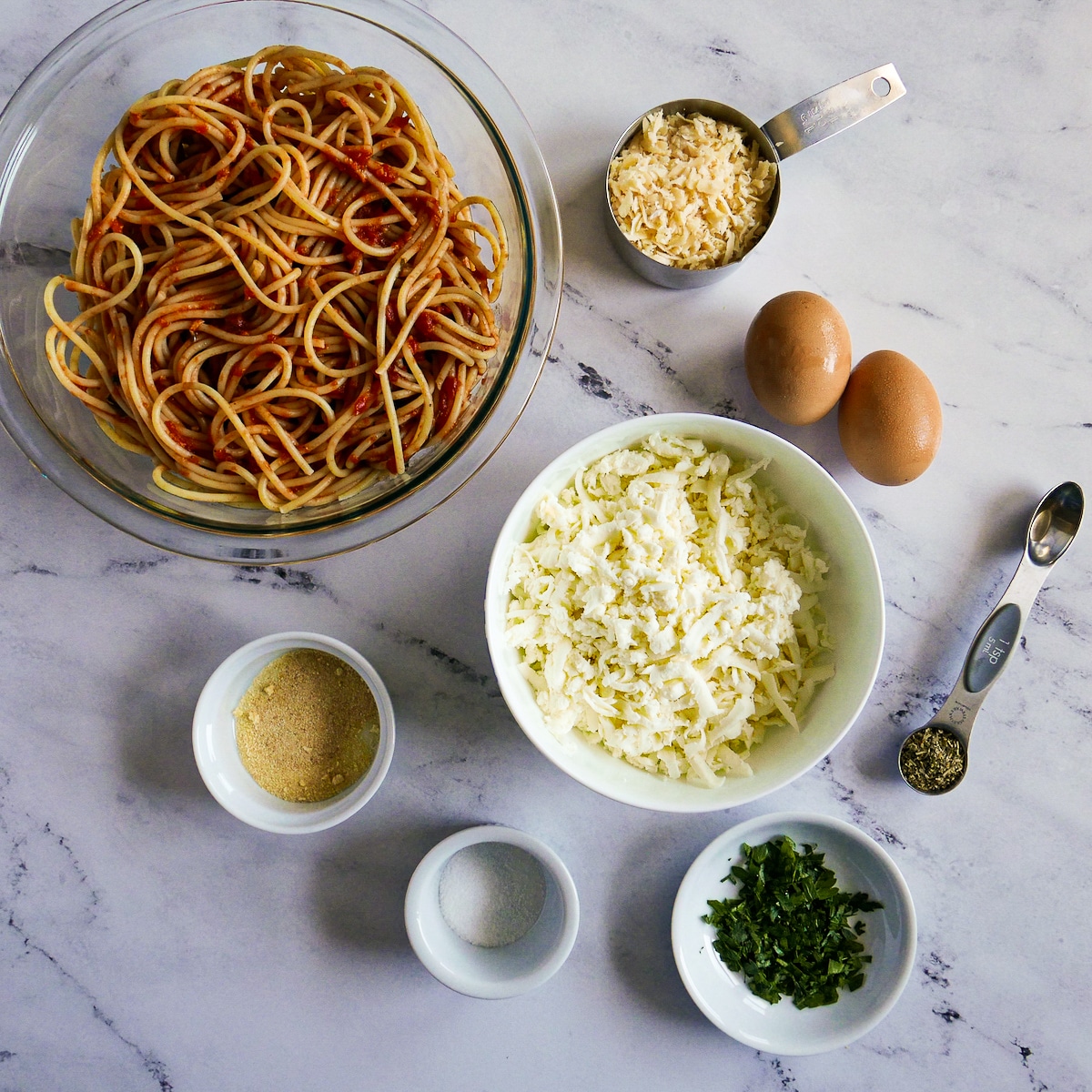 Spaghetti bake recipe ingredients arranged on a table.