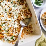 Baked leftover spaghetti in a baking dish with a large spoon.