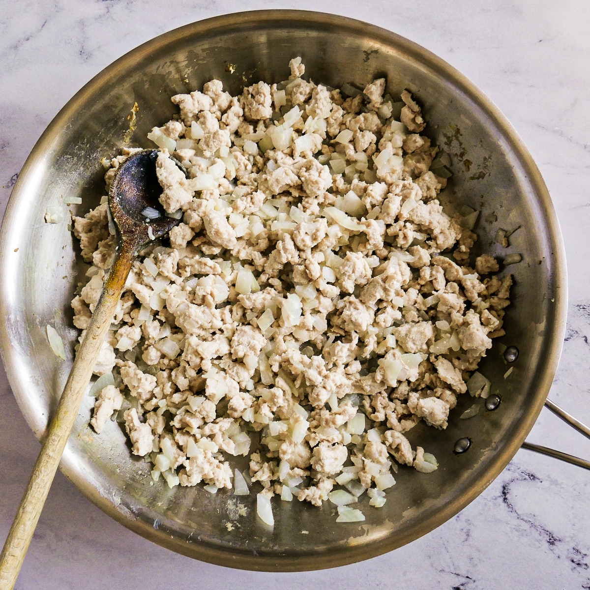 ingredients-cooking-in-skillet.jpg Ground turkey, onion, and garlic cooked in a large skillet.