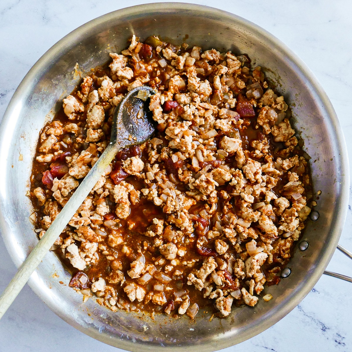 seasoned-ground-meat.jpg Taco seasoning, pasta water, and salsa added to meat mixture in a large pan.