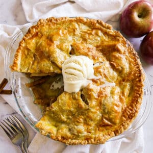 Sliced apple pie with melting ice cream on top.