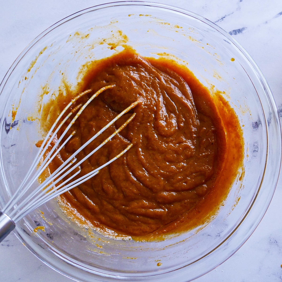 combined-wet-ingredients.jpg Canned pumpkin whisked together with eggs and other ingredients.
