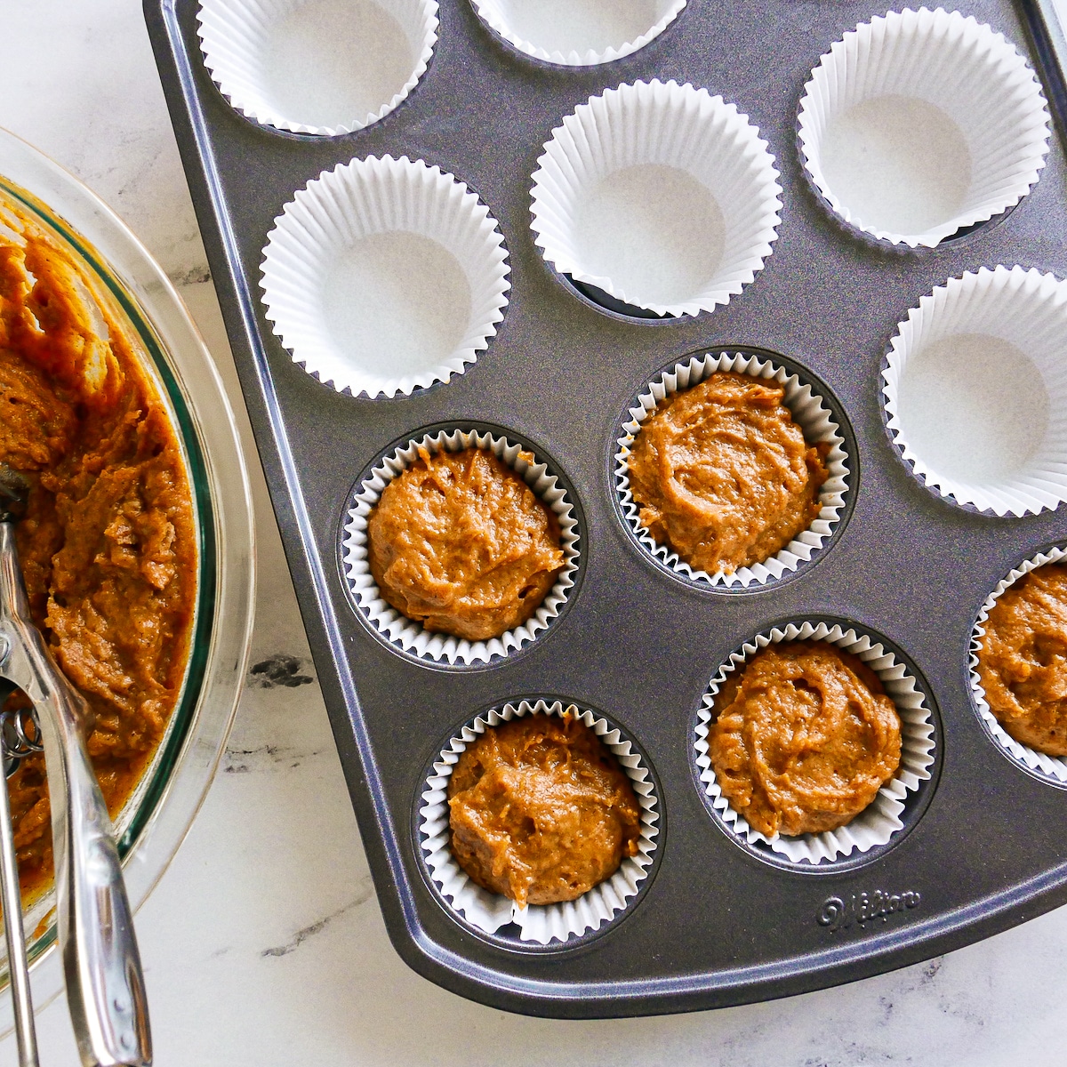 muffin-batter-in-pan.jpg Muffin batter scooped into a prepared muffin pan.