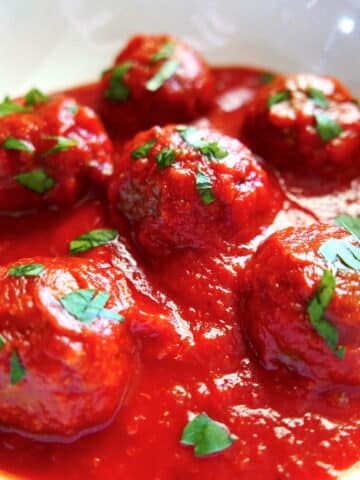 Impossible meatballs resting in a bowl of pasta sauce.