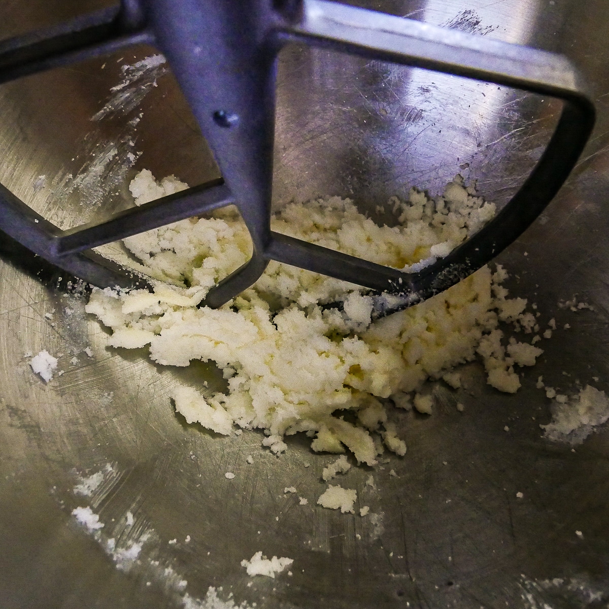 Sugar and butter being mixed together in a stand mixer.