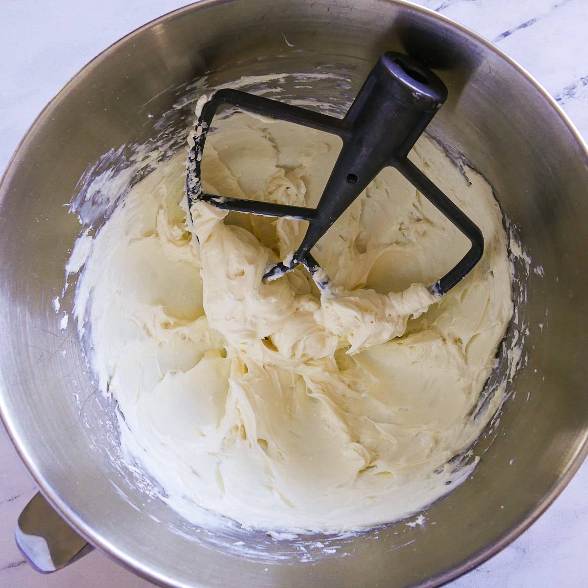 Cream cheese and powdered sugar beat together using a stand mixer.