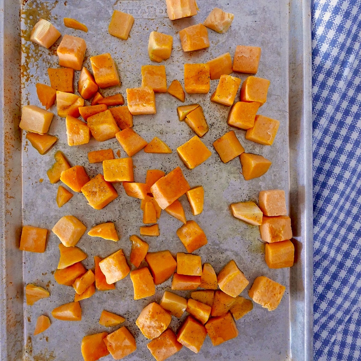 Diced butternut squash on a baking sheet.