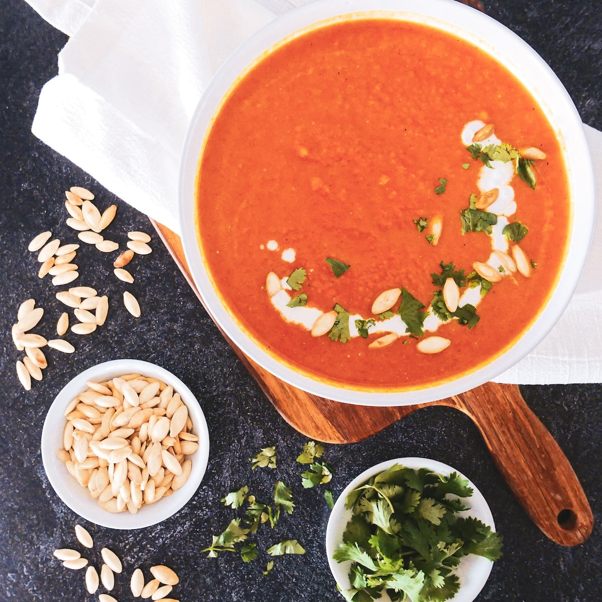 Velvety carrot ginger soup garnished with fresh cilantro.