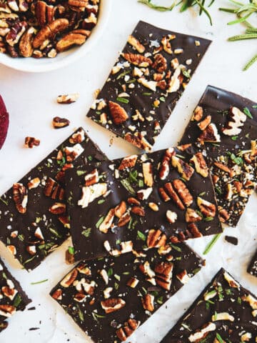 Chocolate pecan bark cut into squares and arranged on a table.